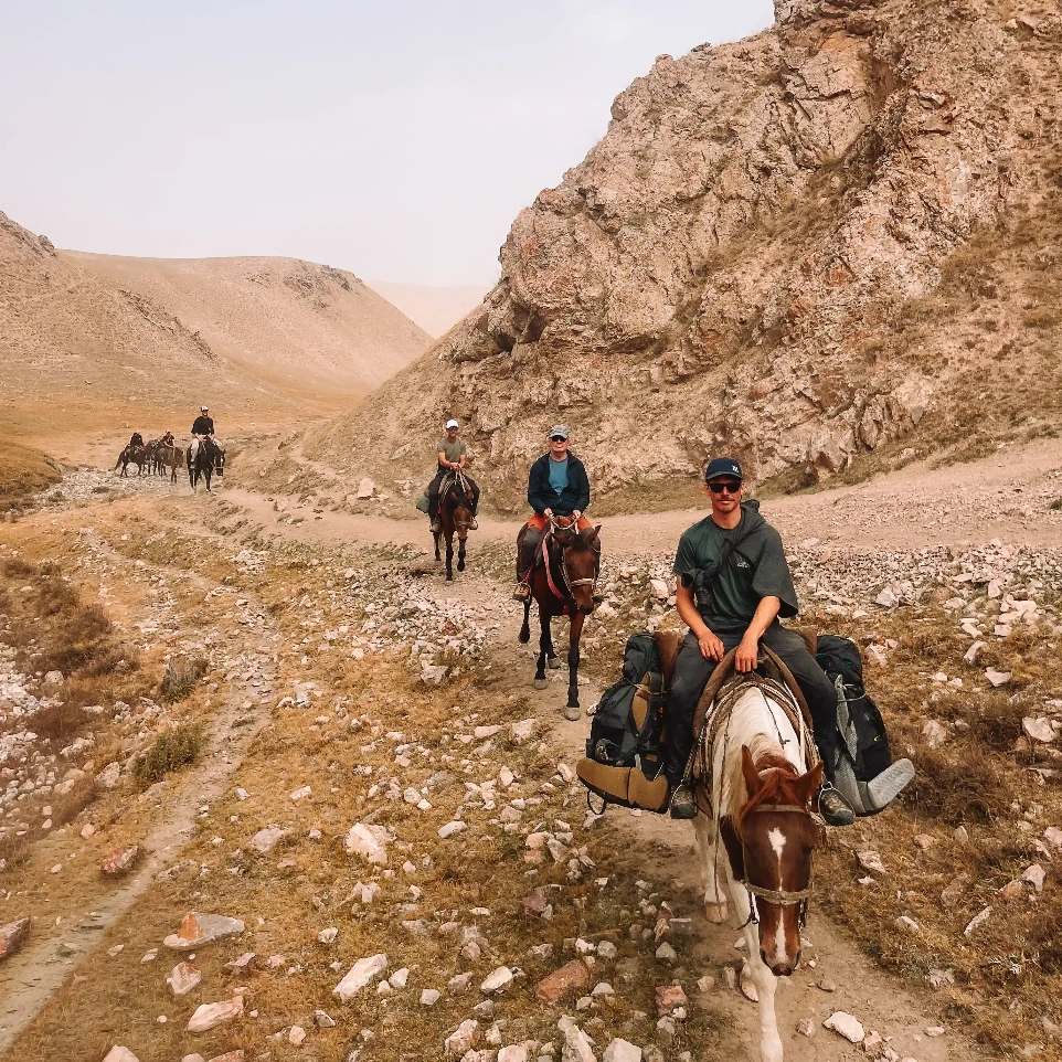 Expeditiegroep te paard door rotsachtig berglandschap in de wildernis