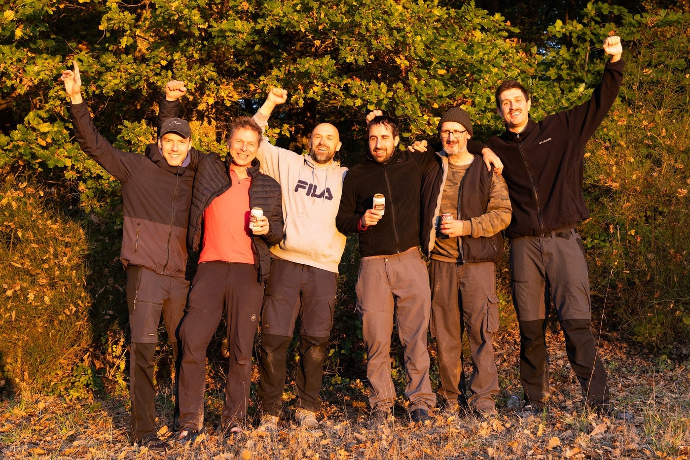 Corporate team celebrating the finish after a multi day trek in the forest