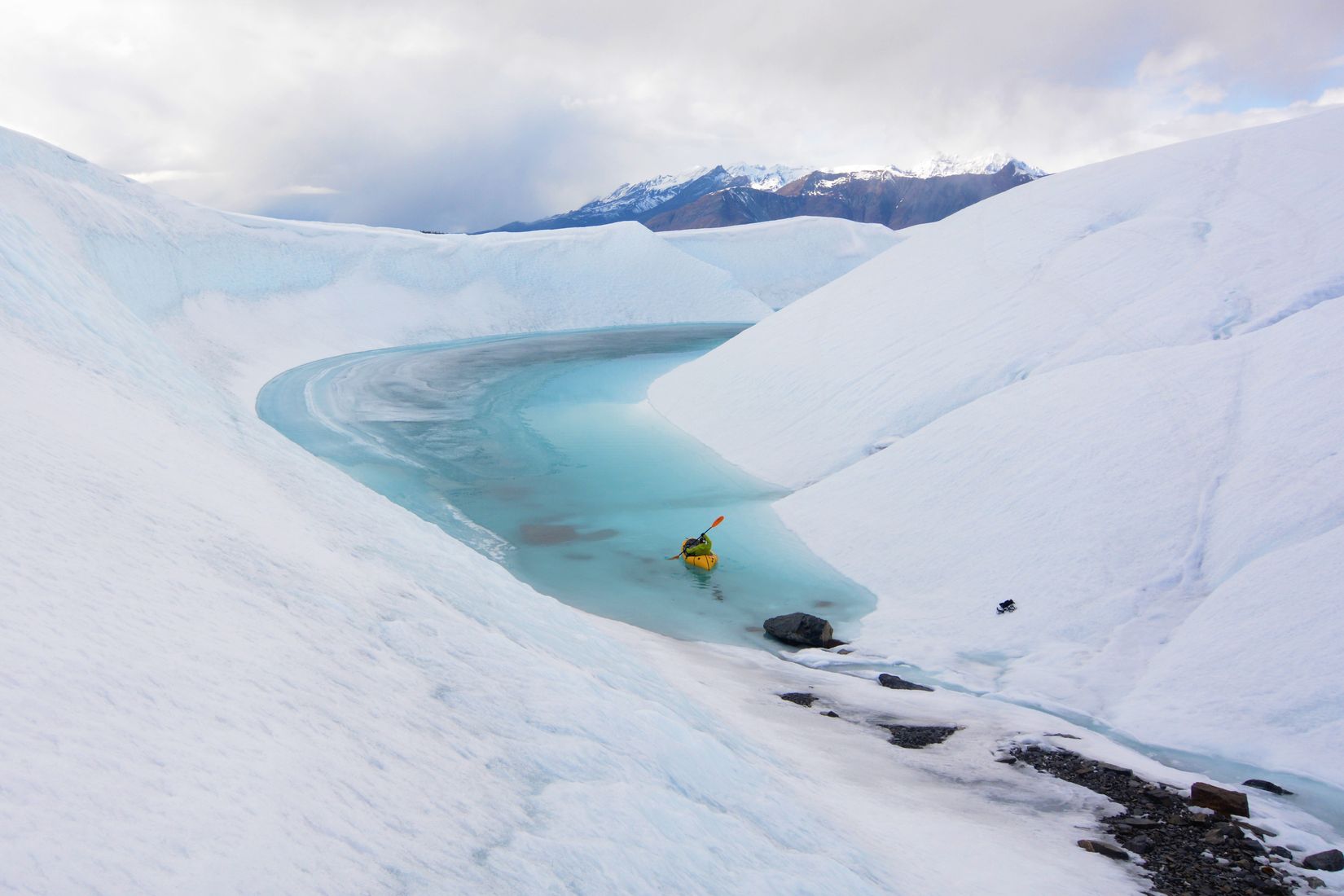 Packraft in a turquoise meltwater channel at the Matanuska glacier in Alaska