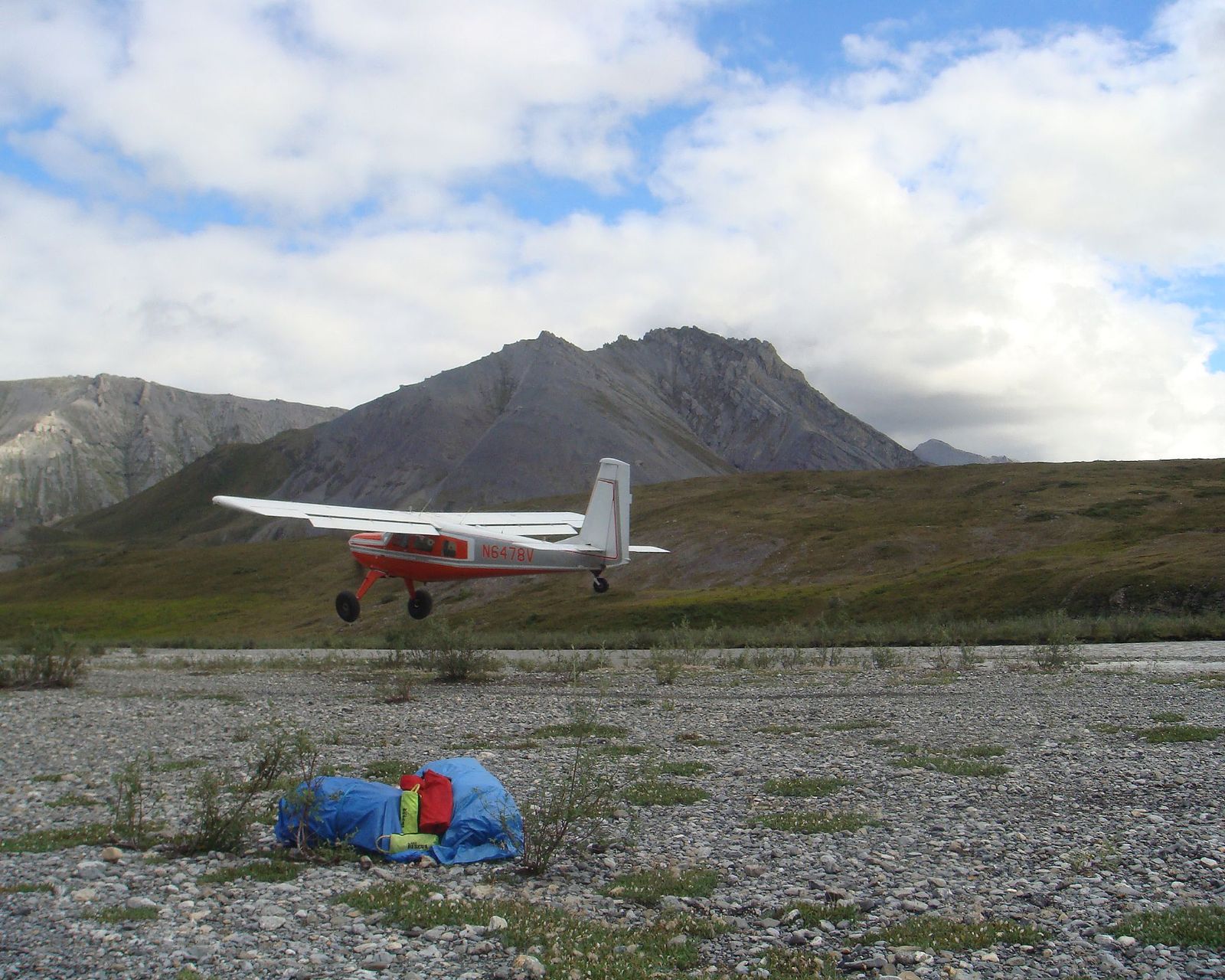 Bush plane with expedition gear on a gravel bar in Alaska