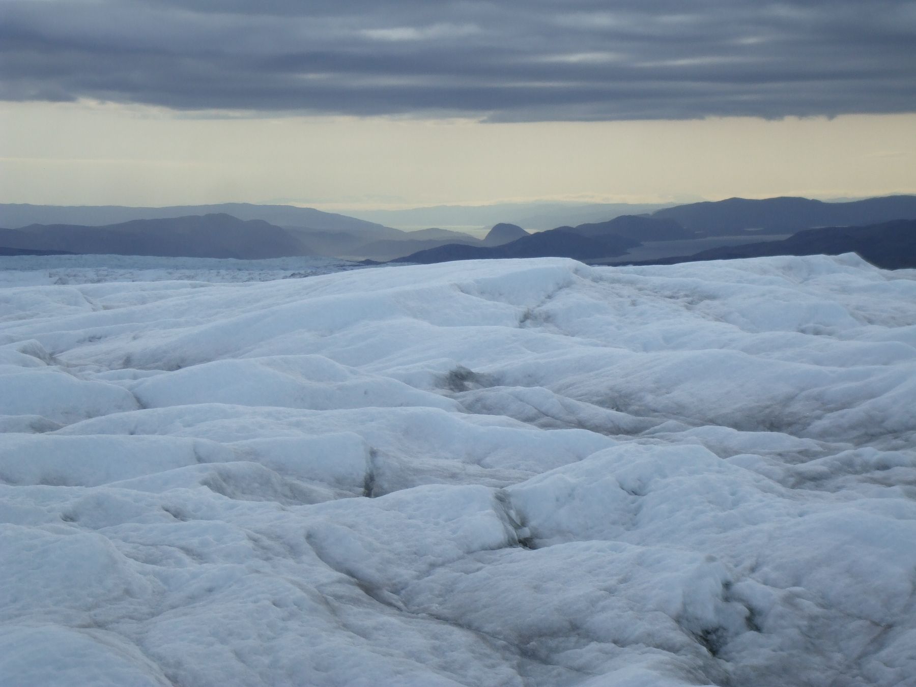 Ice sheet with mountains in the distance in Greenland