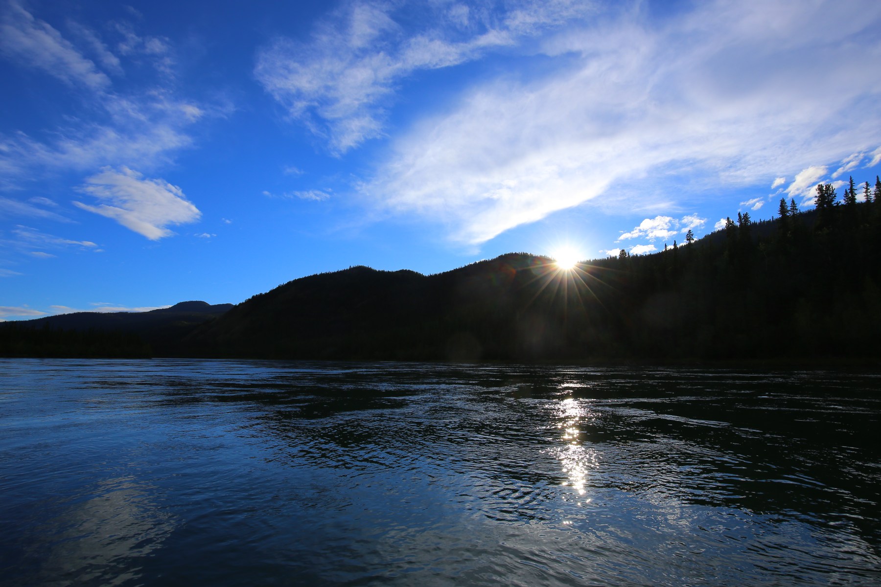 Lage zon boven het water van de Yukon