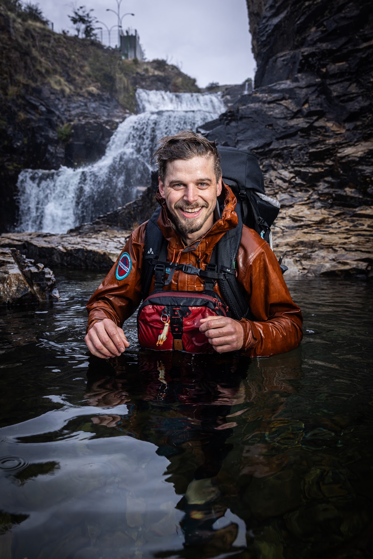 Expeditieleider Koen De Leeuw in een rivier voor een waterval
