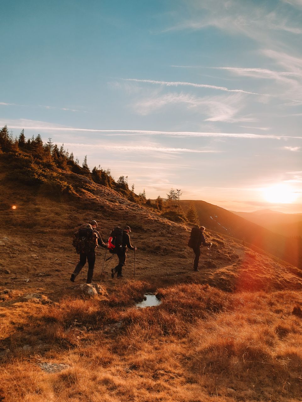 Groep expeditieleden als kleine stippen in een uitgestrekt duinenlandschap