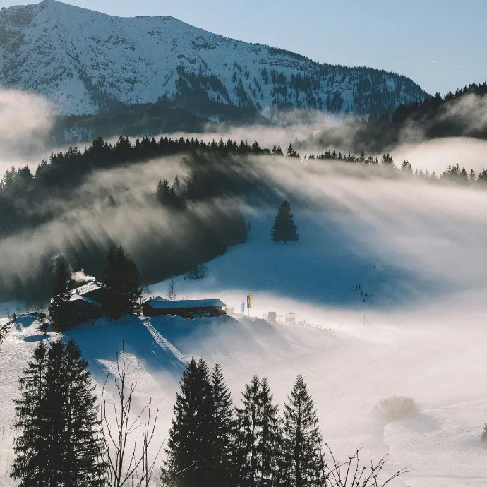 Winterse bergvallei met mist en zonlicht